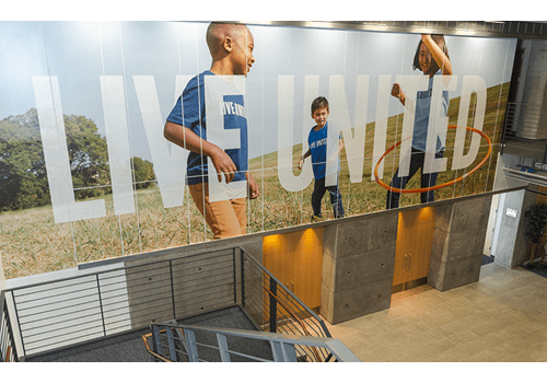 Letrero de United Way con niños corriendo, ubicado en el vestíbulo de Dallas.