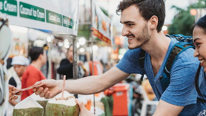 Hombre comprando coco en un mercado extranjero
