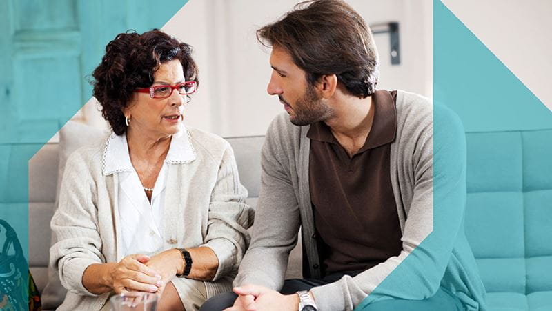 An adult male having a conversation with his mother.